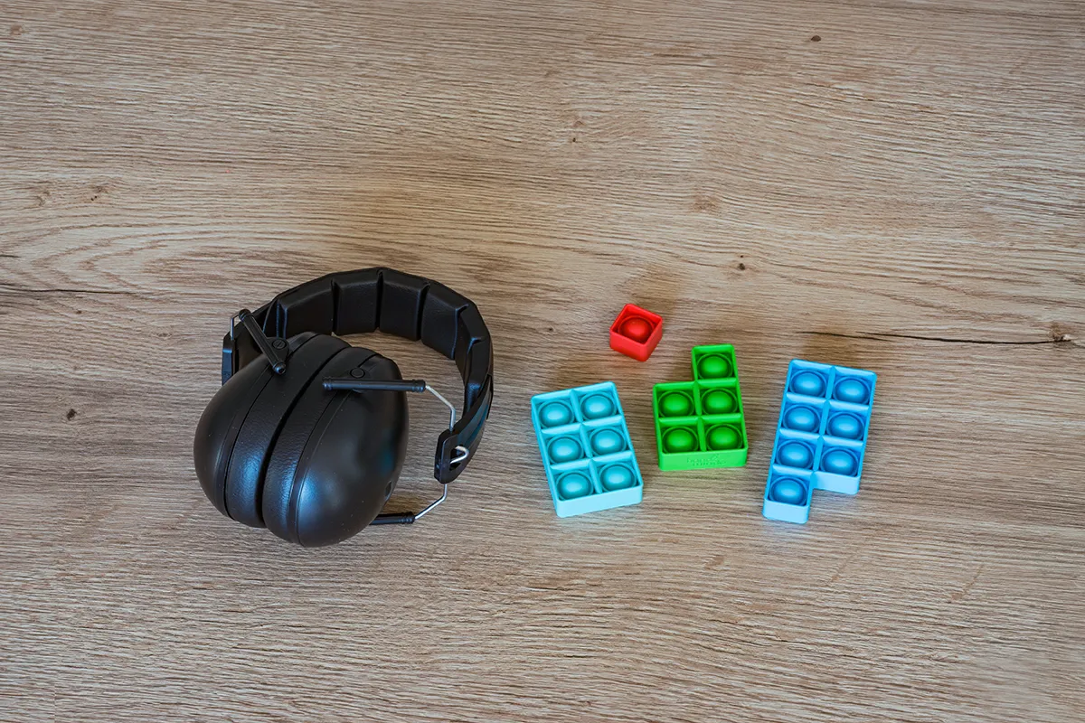Gehörschutz und ein Lernspiel liegen auf einen Tisch